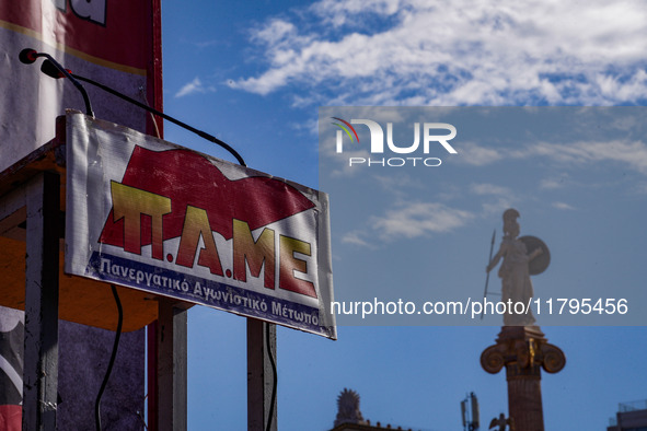 The logo of the All-Workers Militant Front (PAME) is displayed with the statue of the goddess Athena at the University of Athens in the back...