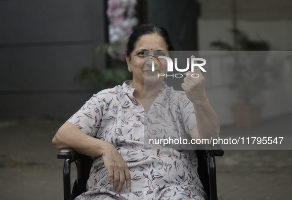 An Indian voter poses with her inked finger after casting her ballot during the Maharashtra state assembly elections at a polling booth in M...