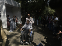 A man in a wheelchair casts his ballot to vote during the Maharashtra state assembly elections at a polling booth in Mumbai, India, on Novem...