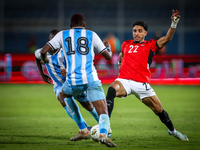 Omar Marmoush of the Egypt team battles for possession with Godiraone Modingwane and Lebogang Ditsele of the Botswana team during the Africa...