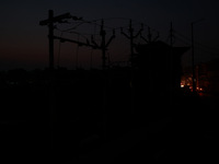 Vehicles move as the surrounding area reels under darkness due to the unavailability of electricity in Sopore, Jammu and Kashmir, India, on...