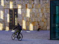 A cyclist and a pedestrian move across St. Jakob's Square in Munich, Germany, on January 7, 2023, near the portal of the Ohel Jakob synagogu...