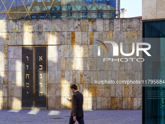 A man walks across St. Jakob's Square in Munich, Germany, on January 7, 2023, adjacent to the portal of the Ohel Jakob synagogue. The limest...