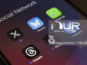 The logos of the social networks X (Twitter), Bluesky, WhatsApp, Threads, TikTok, and Facebook are displayed on the screen of a smartphone i...