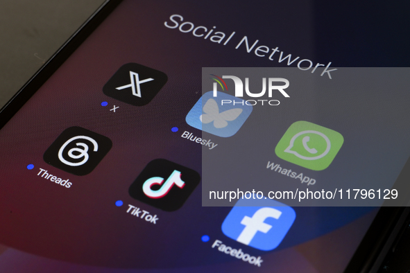 The logos of the social networks X (Twitter), Bluesky, WhatsApp, Threads, TikTok, and Facebook are displayed on the screen of a smartphone i...