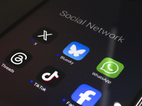 The logos of the social networks X (Twitter), Bluesky, WhatsApp, Threads, TikTok, and Facebook are displayed on the screen of a smartphone i...