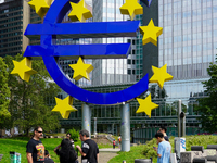 Visitors admire the monumental Euro sculpture by Ottmar Horl, located at Willy-Brandt-Platz in Frankfurt am Main, Germany, on August 15, 202...