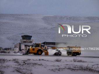 A snowplow clears the landing strip at the airfield in the town of Husavik, Iceland, on November 19, 2024. (