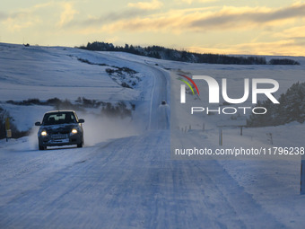 A car drives on one of the roads around the town of Husavik, Iceland, on November 19, 2024. (