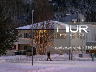 A person walks down a street in the town of Husavik, Iceland, on November 19, 2024. (