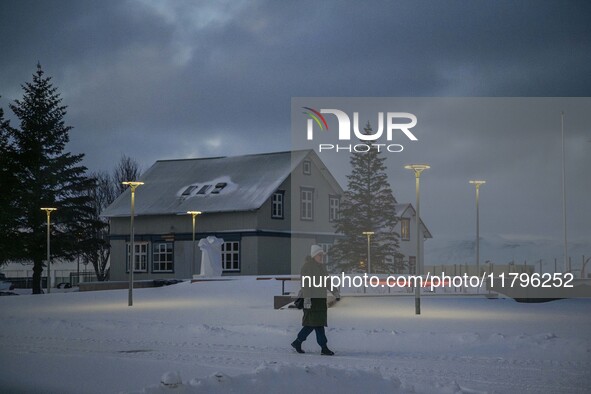 A person walks down a street in the town of Husavik, Iceland, on November 19, 2024. 