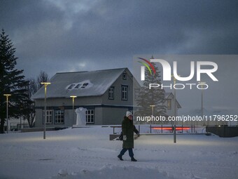 A person walks down a street in the town of Husavik, Iceland, on November 19, 2024. (