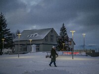 A person walks down a street in the town of Husavik, Iceland, on November 19, 2024. (