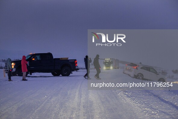 People help a vehicle involved in an accident on a road near the town of Husavik, Iceland, on November 19, 2024. 