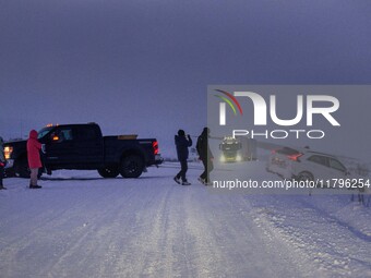 People help a vehicle involved in an accident on a road near the town of Husavik, Iceland, on November 19, 2024. (