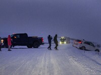 People help a vehicle involved in an accident on a road near the town of Husavik, Iceland, on November 19, 2024. (