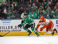 Miro Heiskanen #4 of the Dallas Stars and Leo Carlsson of the Anaheim Ducks battle for the puck during the NHL regular season match at the A...