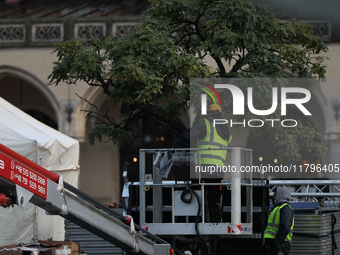 Workers put up Christmas lights on a tree in the Main Square in Krakow, Poland, on November 18, 2024. (