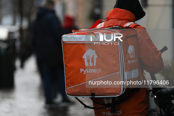 A courier from Pyszne.pl on a bike is seen on the street in Krakow, Poland, on November 18, 2024. 