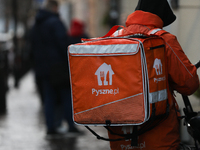 A courier from Pyszne.pl on a bike is seen on the street in Krakow, Poland, on November 18, 2024. (