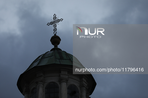 A church tower with a cross in the sky is visible on the street in Krakow, Poland, on November 18, 2024. 