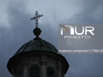 A church tower with a cross in the sky is visible on the street in Krakow, Poland, on November 18, 2024. (