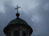 A church tower with a cross in the sky is visible on the street in Krakow, Poland, on November 18, 2024. (