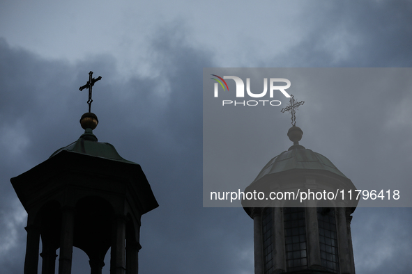 A church tower with a cross in the sky is visible on the street in Krakow, Poland, on November 18, 2024. 