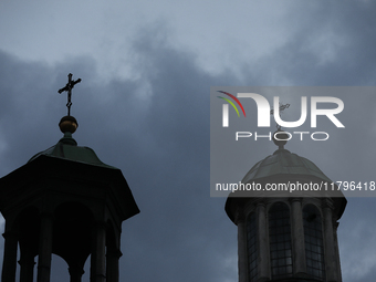 A church tower with a cross in the sky is visible on the street in Krakow, Poland, on November 18, 2024. (