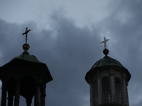 A church tower with a cross in the sky is visible on the street in Krakow, Poland, on November 18, 2024. (