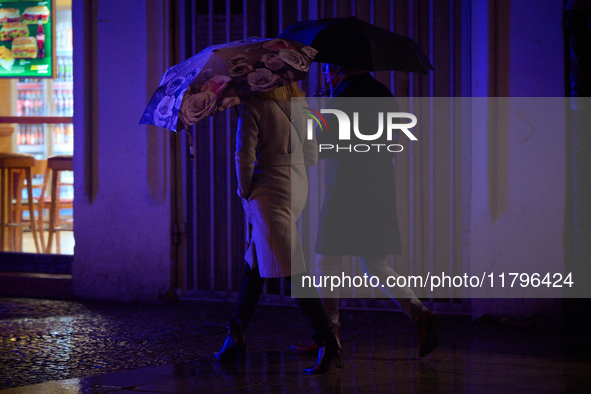 A pedestrian with an umbrella is seen in a shopping street during rainfall in Warsaw, Poland on 20 November, 2024. 