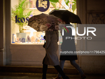 A pedestrian with an umbrella is seen in a shopping street during rainfall in Warsaw, Poland on 20 November, 2024. (