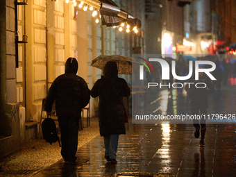 A pedestrian with an umbrella is seen in a shopping street during rainfall in Warsaw, Poland on 20 November, 2024. (