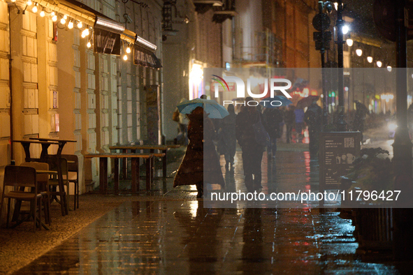 A pedestrian with an umbrella is seen in a shopping street during rainfall in Warsaw, Poland on 20 November, 2024. 