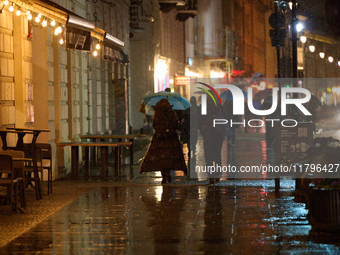 A pedestrian with an umbrella is seen in a shopping street during rainfall in Warsaw, Poland on 20 November, 2024. (