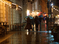 A pedestrian with an umbrella is seen in a shopping street during rainfall in Warsaw, Poland on 20 November, 2024. (