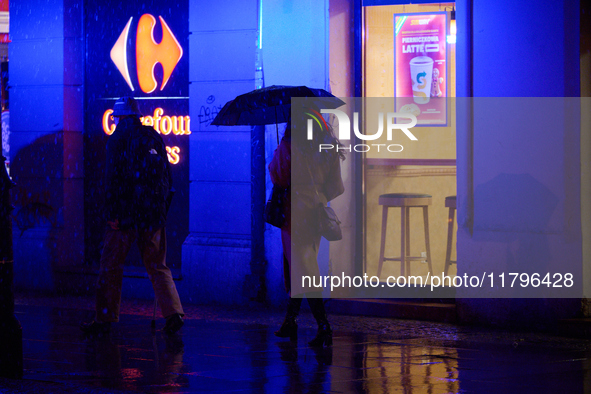 A pedestrian with an umbrella is seen in a shopping street during rainfall in Warsaw, Poland on 20 November, 2024. 