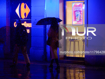 A pedestrian with an umbrella is seen in a shopping street during rainfall in Warsaw, Poland on 20 November, 2024. (