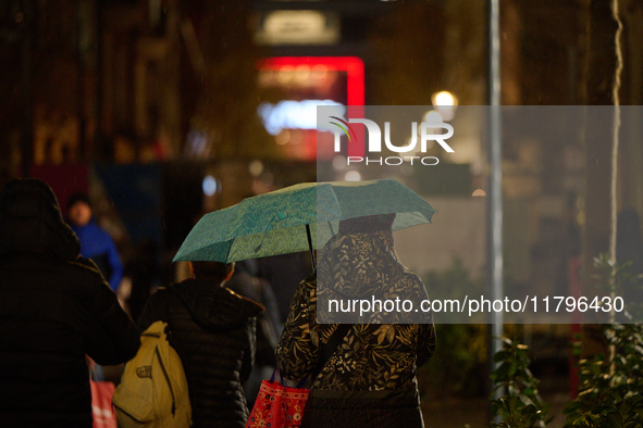 A pedestrian with an umbrella is seen in a shopping street during rainfall in Warsaw, Poland on 20 November, 2024. 