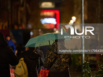 A pedestrian with an umbrella is seen in a shopping street during rainfall in Warsaw, Poland on 20 November, 2024. (