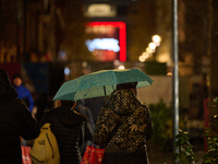 A pedestrian with an umbrella is seen in a shopping street during rainfall in Warsaw, Poland on 20 November, 2024. (