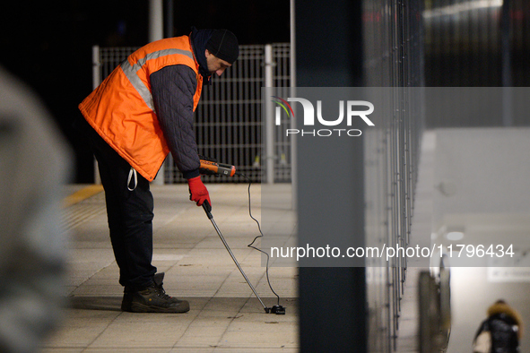 A worker is seen with a light meter on a train platform in Warsaw, Poland on 20 November, 2024. 