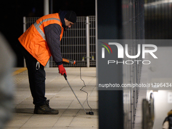 A worker is seen with a light meter on a train platform in Warsaw, Poland on 20 November, 2024. (