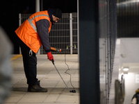 A worker is seen with a light meter on a train platform in Warsaw, Poland on 20 November, 2024. (