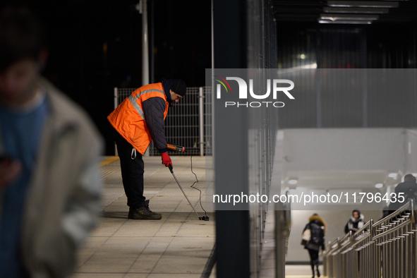 A worker is seen with a light meter on a train platform in Warsaw, Poland on 20 November, 2024. 