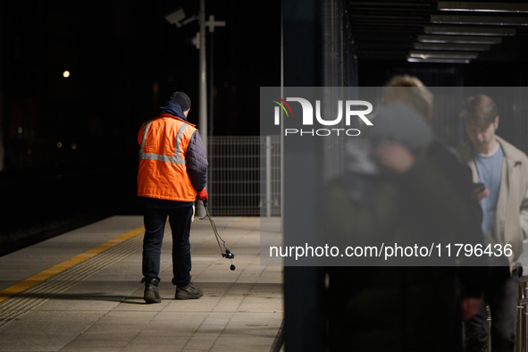 A worker is seen with a light meter on a train platform in Warsaw, Poland on 20 November, 2024. 