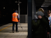 A worker is seen with a light meter on a train platform in Warsaw, Poland on 20 November, 2024. (