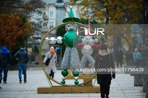 People walk past Christmas lights decoratoins prepared for the upcoming season in Warsaw, Poland on 18 November, 2024. Warsaw is an increasi...