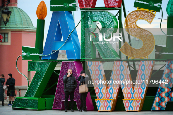 People walk past Christmas lights decoratoins prepared for the upcoming season in Warsaw, Poland on 18 November, 2024. Warsaw is an increasi...