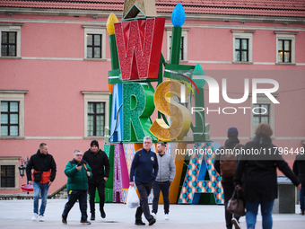 People walk past Christmas lights decoratoins prepared for the upcoming season in Warsaw, Poland on 18 November, 2024. Warsaw is an increasi...